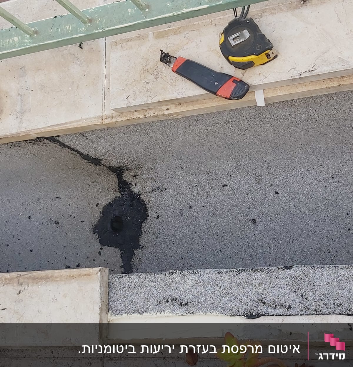 כלי עבודה וסרט מדידה על משטח אטום בזפת